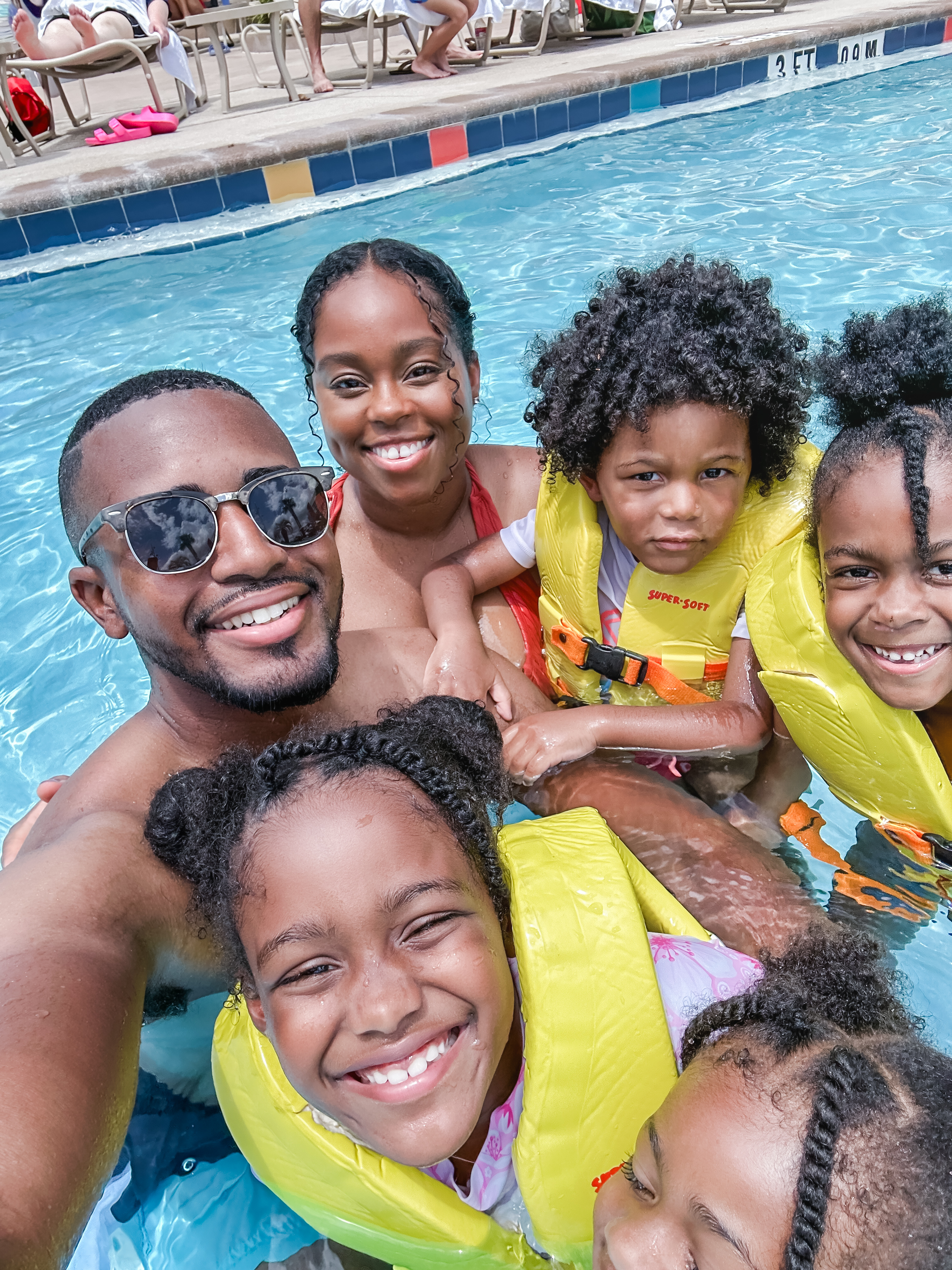 The Roberson family together in the zero entry pool at Cabana Bay Beach Resort wearing life jackets