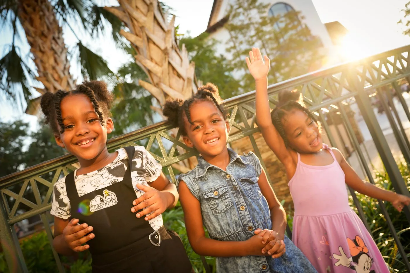 Three Roberson daughters laughing together at golden hour at Disney Springs
