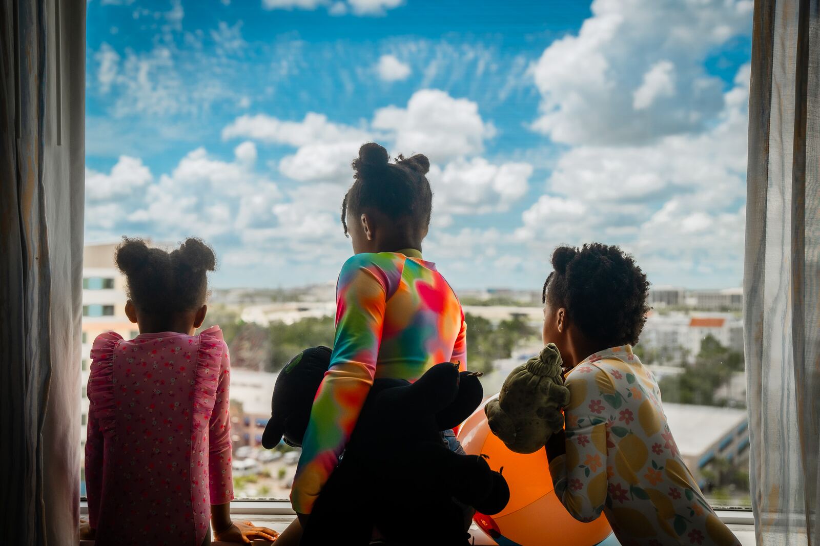 Roberson kids looking out the hotel window at the Orlando skyline from their room at Universal's Endless Summer Resort