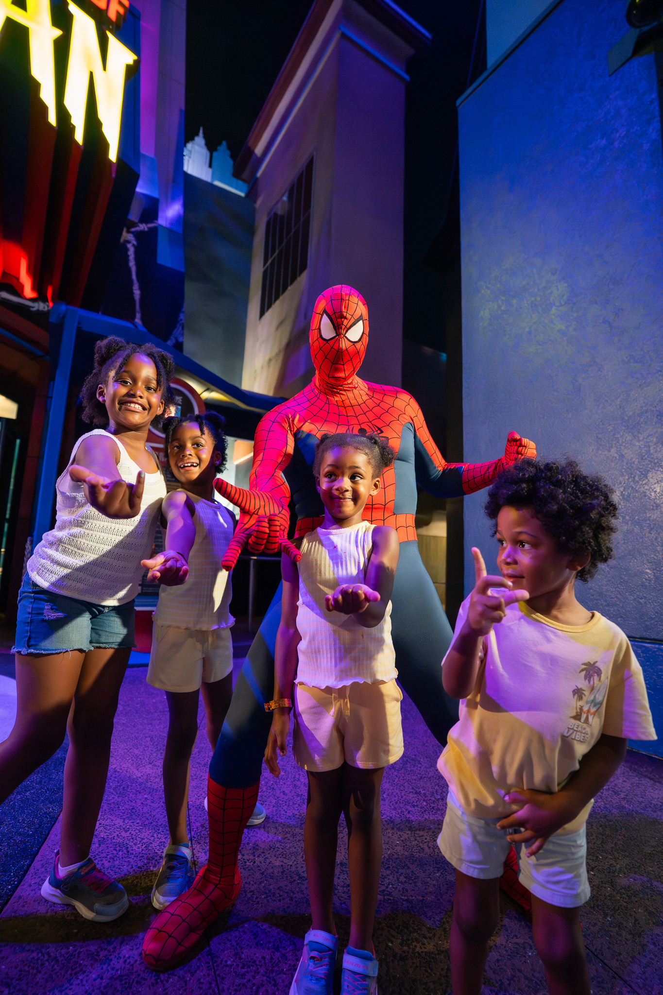 Roberson kids posing with Spider-Man at the Orlando Informer Meetup at night